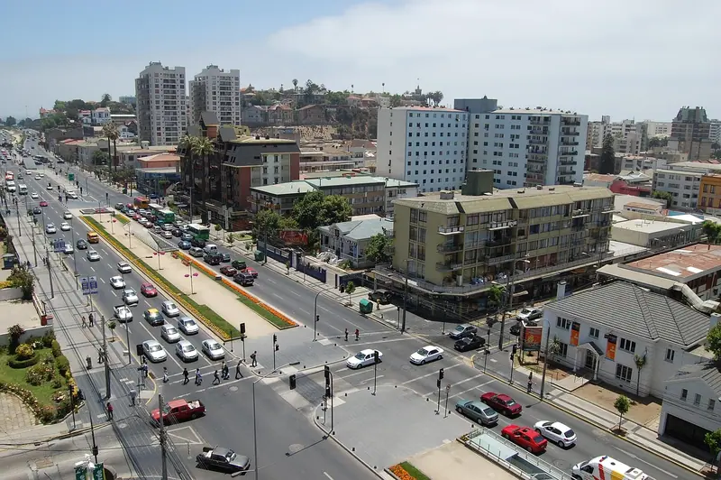 Avenida movimentada com carros e prédios residenciais dos dois lados
