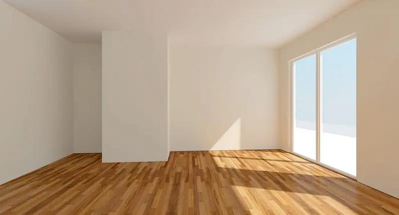 Sala vazia de apartamento com piso de madeira e porta de vidro iluminada pelo sol