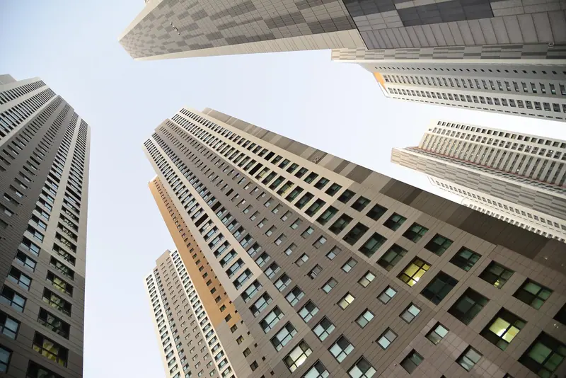Torres residenciais altas vistas de baixo, contra o céu claro