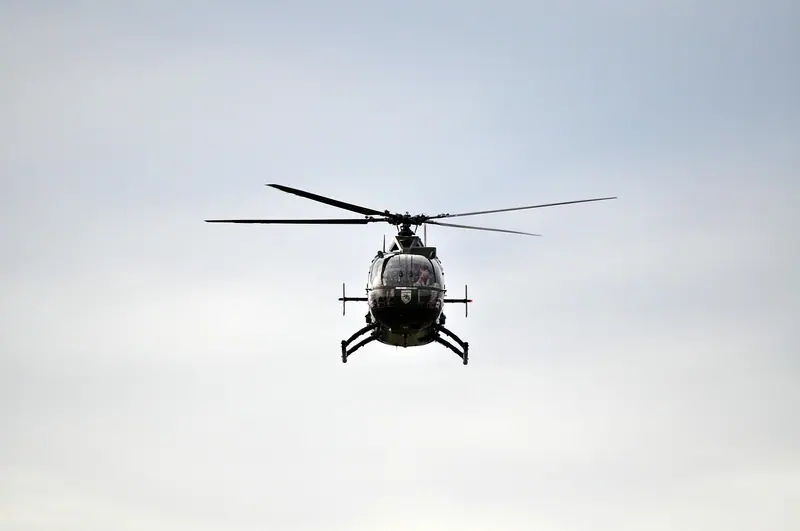 Helicóptero visto de baixo, de frente, contra um céu cinza
