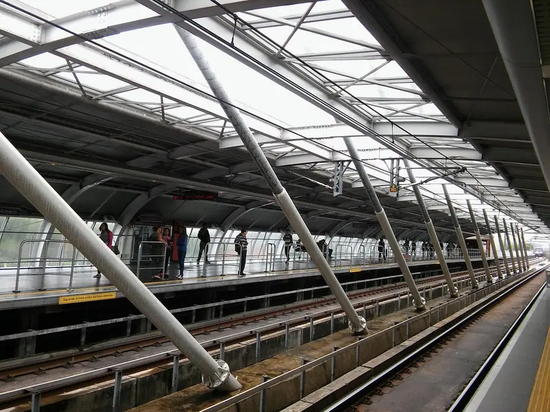 Plataforma de estação elevada com cobertura metálica e trilhos ao lado