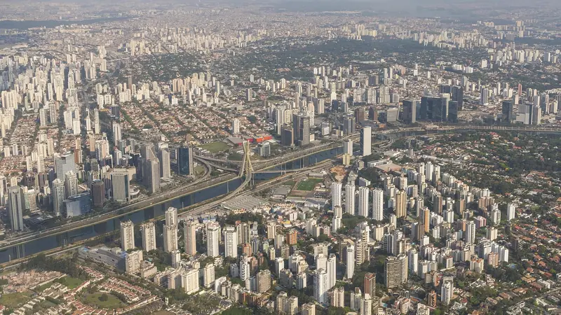 Vista aérea de São Paulo com prédios, uma via expressa e um rio cortando a cidade