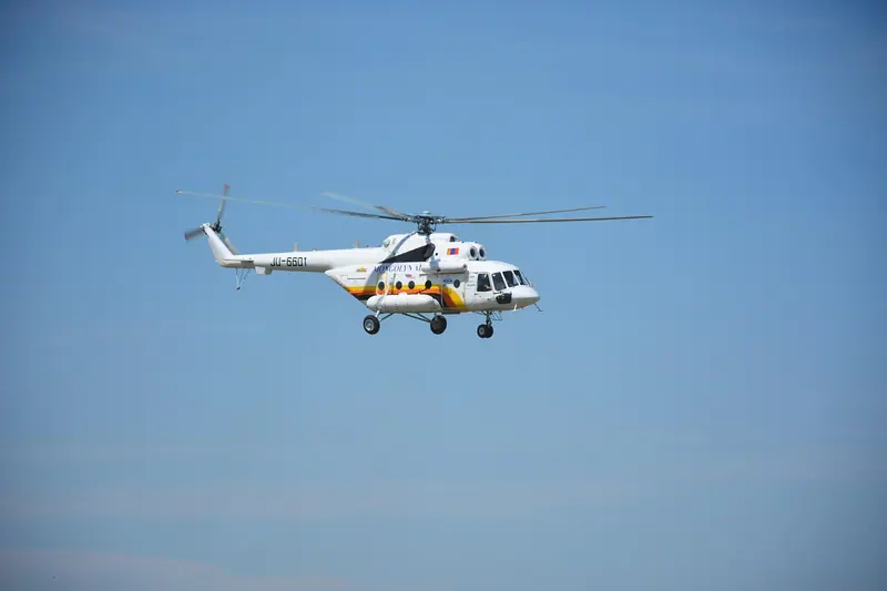 Helicóptero branco voando ao longe num céu azul limpo