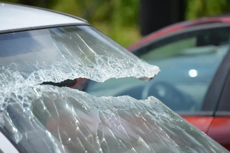 Para-brisa de carro estilhaçado, com o vidro trincado ainda preso no lugar