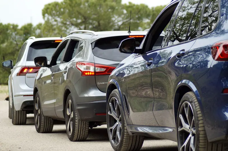 Carros enfileirados num congestionamento, vistos de perto pela traseira