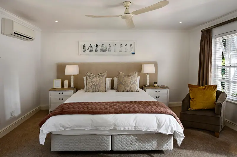 Quarto com cabeceira encostada na parede e a janela na parede lateral