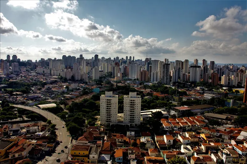 Vista aérea de bairro de São Paulo com casas, prédios altos e uma avenida em curva