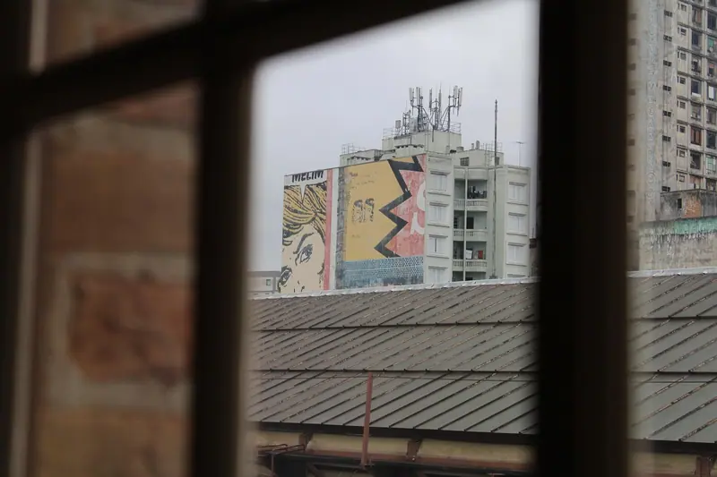 Prédio da cidade visto através do caixilho escuro de uma janela