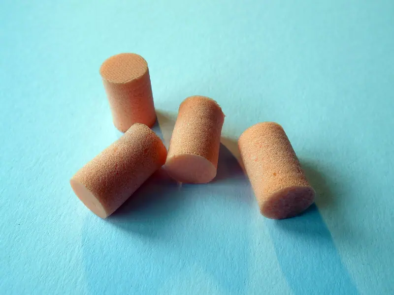 Quatro protetores auriculares de espuma sobre um fundo azul