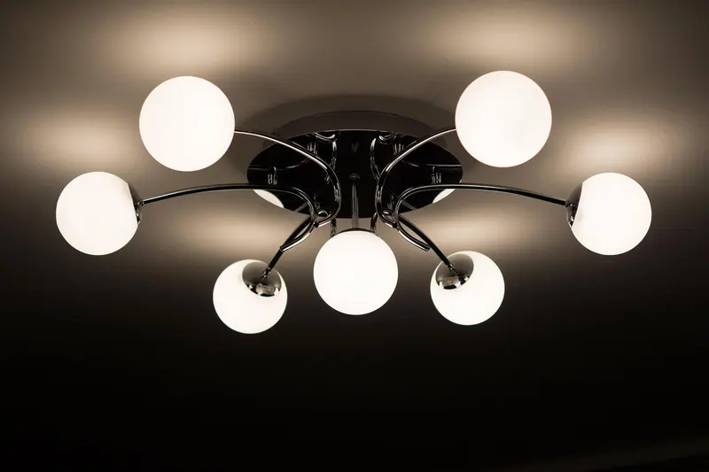 Luminária de teto com várias cúpulas brancas acesas, vista de baixo
