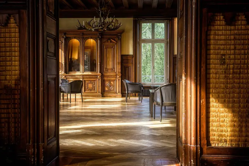 Portas de madeira abertas para uma sala clássica e elegante, com piso de madeira e luz natural