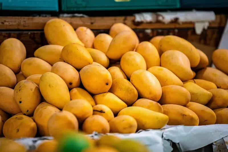 Mangas amarelas empilhadas numa banca de feira