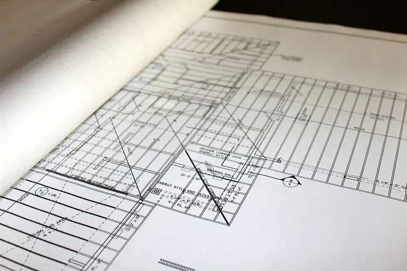 Planta técnica de um projeto impressa em papel, com linhas e medidas, vista de perto