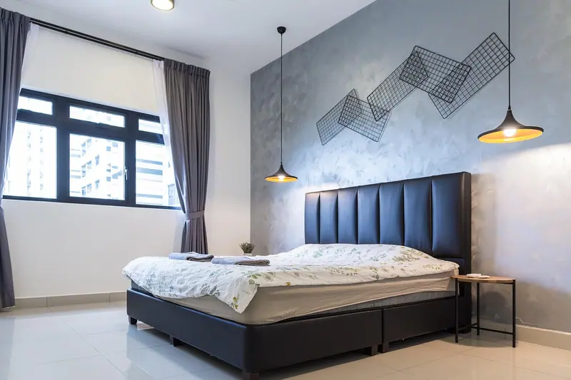 Quarto claro com cama de cabeceira escura e janela de caixilho preto com cortinas