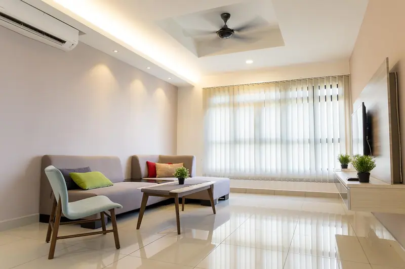 Sala com sofá, cortinas claras na janela e aparelho de ar-condicionado na parede
