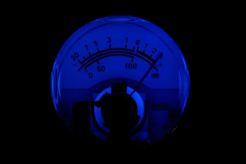 Mostrador analógico iluminado de azul com escala em decibéis