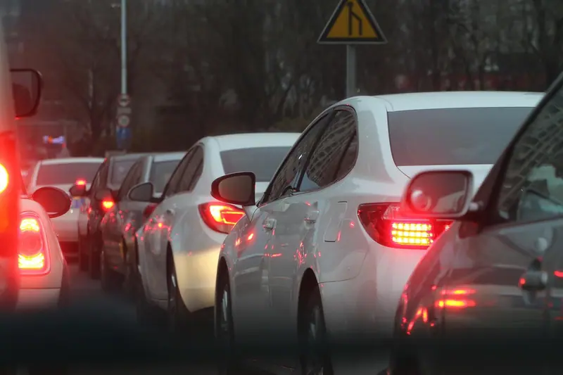 Carros parados no trânsito com as luzes de freio acesas no fim da tarde