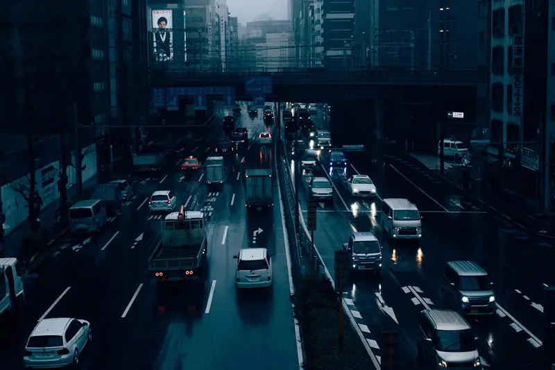 Avenida movimentada com várias faixas de carros, vista do alto entre prédios