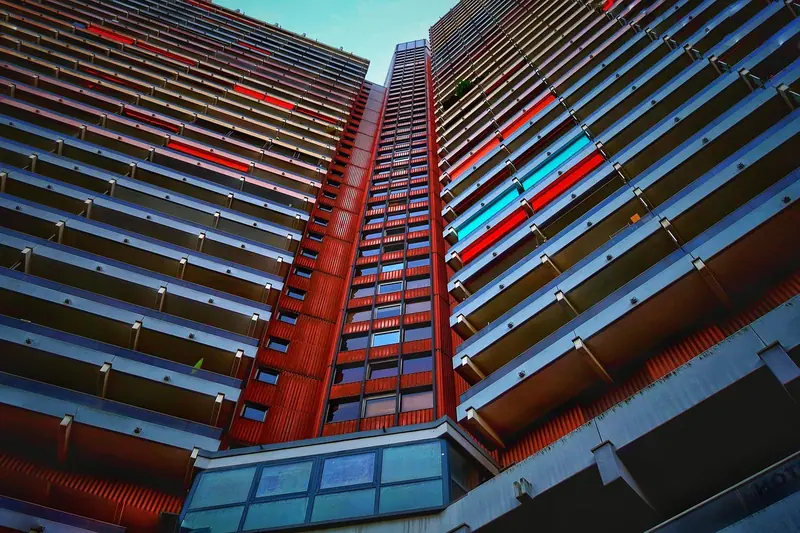 Prédio residencial alto visto de baixo, com fileiras de varandas até o céu
