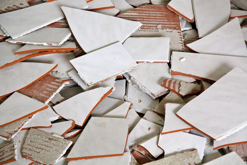 Pilha de cacos de azulejo branco espalhados pelo chão