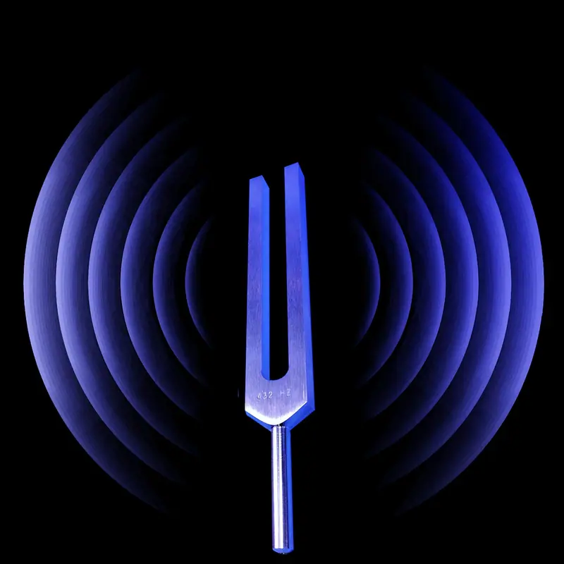 Diapasão de metal na frente de círculos de luz azul que lembram ondas sonoras