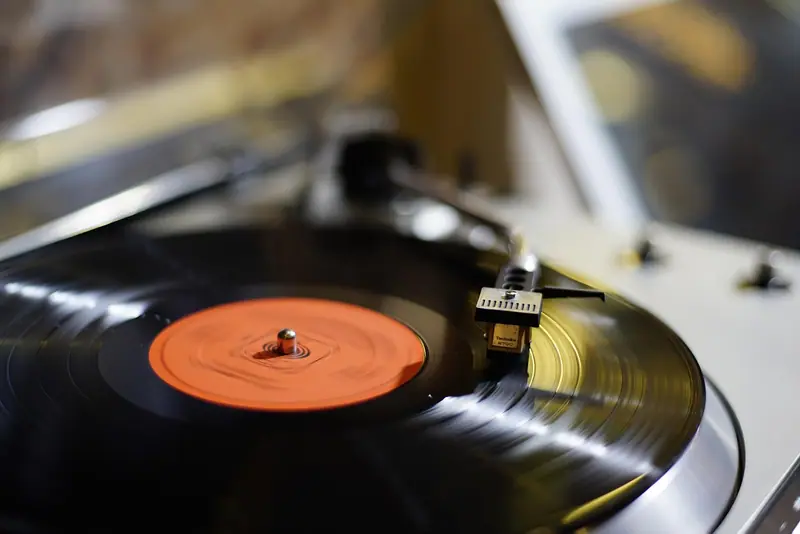 Disco de vinil girando num toca-discos, com o braço da agulha sobre ele